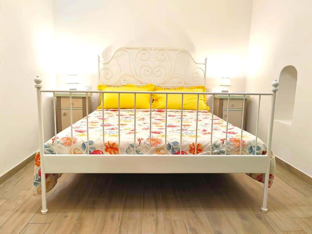 Letto matrimoniale con testiera in ferro battuto nella camera accogliente di Dimora Acquamarina, casa vacanze a Monopoli centro storico